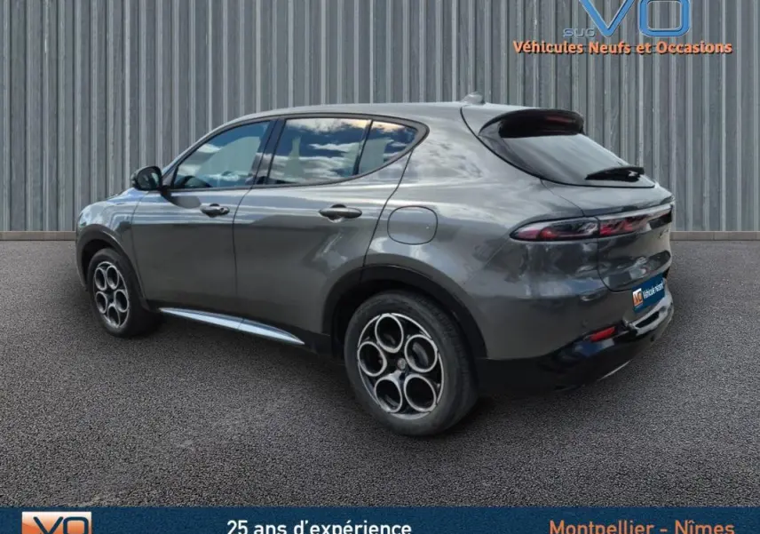 Vue 3/4 arrière côté gauche d'une Alfa Romeo Tonale grise avec jantes alliage 18 pouces et feux arrière effilés.