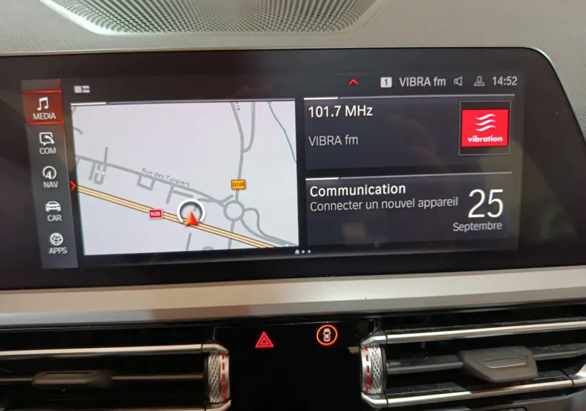 Écran tactile central de la BMW Série 3 316d 2022 affichant navigation et radio, avec commandes de climatisation visibles.