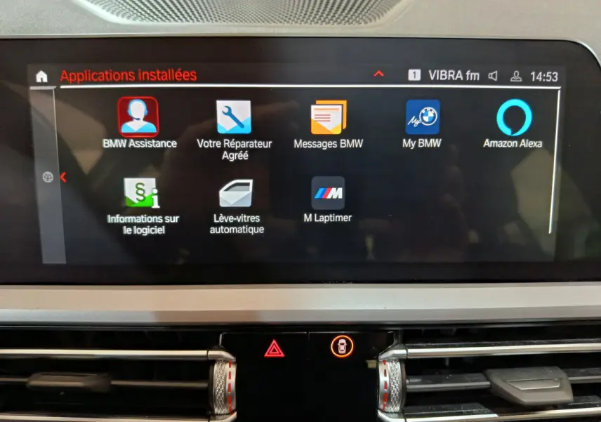 Écran tactile central affichant les applications BMW et Alexa dans l'habitacle d'une BMW Série 3 gris clair.