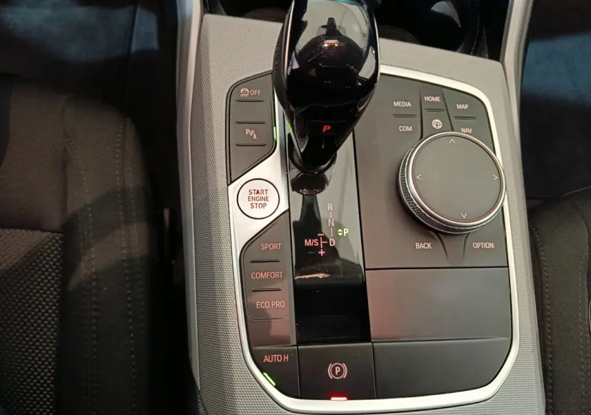 Vue rapprochée de la console centrale de la BMW Série 3 316d 2022 avec levier de vitesses et commandes multimodes.