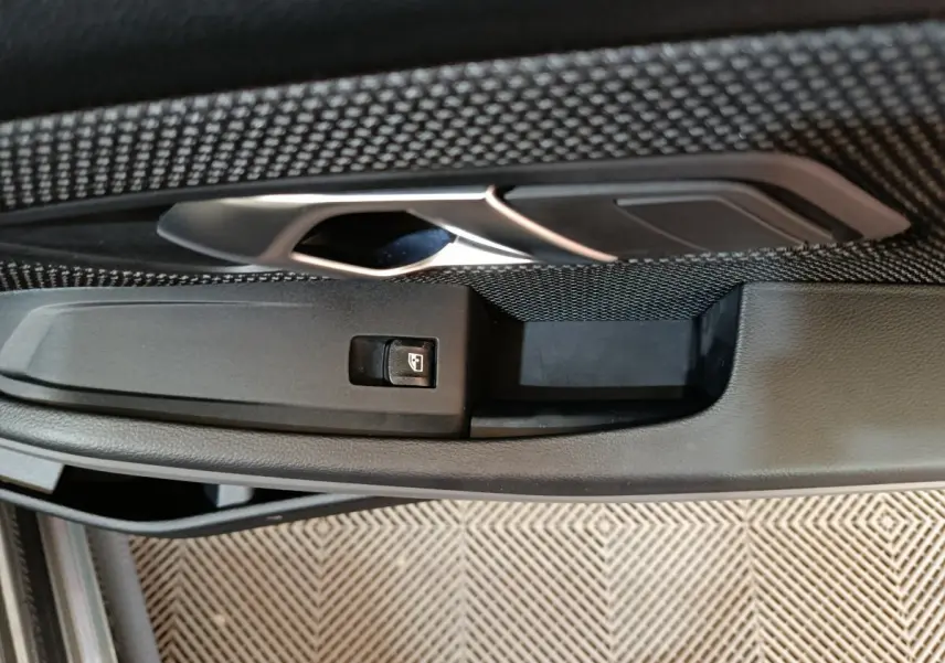 Poignée intérieure de porte côté gauche avec bouton de commande de vitre sur BMW Série 3 gris clair 316d Business Design 2022.