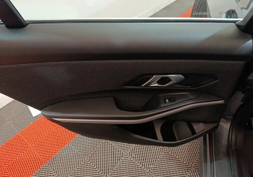 Vue côté gauche de la porte intérieure noire de la BMW Série 3 316d Business Design 2022 avec poignée argentée.