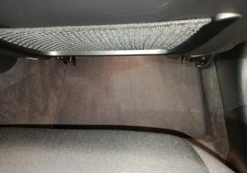 Espace au sol côté passager avant de la BMW Série 3 316d 2022 avec tapis gris foncé et filet de rangement sous tableau de bord.