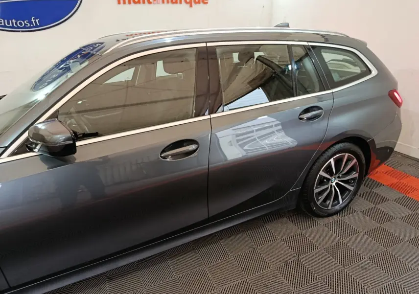 Vue latérale côté gauche d'une BMW Série 3 Touring gris clair avec jantes alliage et vitres teintées.