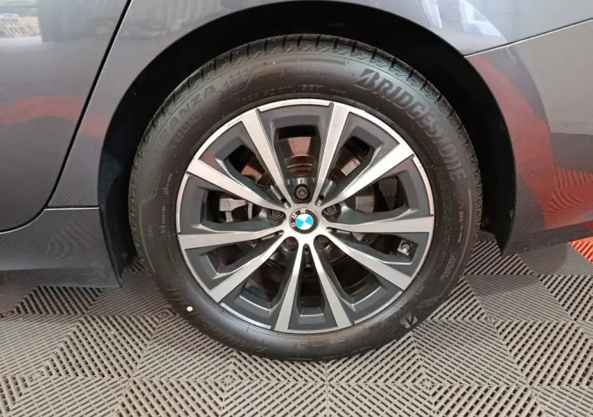 Gros plan sur la roue arrière droite gris clair d'une BMW Série 3 316d avec jante alliage et pneu Bridgestone.