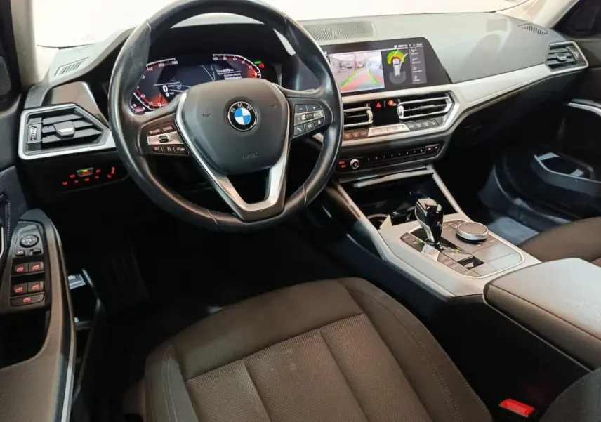 Intérieur BMW Série 3 316d 2022 vu côté conducteur, volant cuir, tableau de bord digital et écran tactile central.