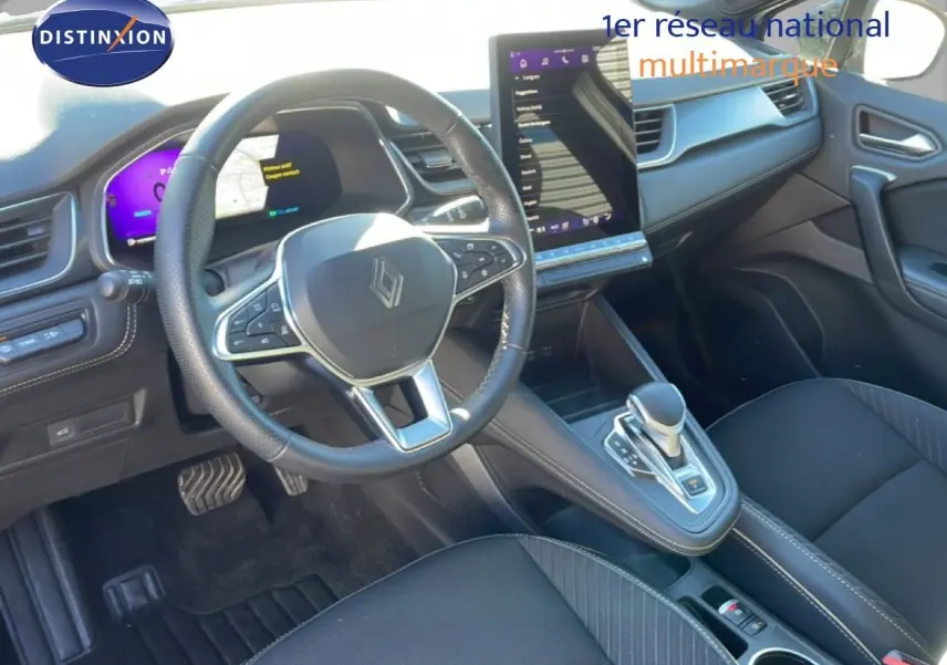 Vue intérieure centrée sur le volant et la console centrale de la Renault Symbioz 2025, finition Iconic, avec écran tactile vertical.