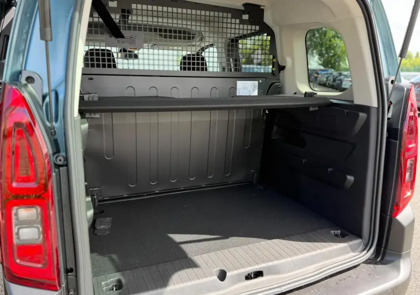 Coffre ouvert vu de l'arrière d'un Citroën Berlingo Multispace bleu Kiama avec lunette arrière ouvrante et séparation intérieure.