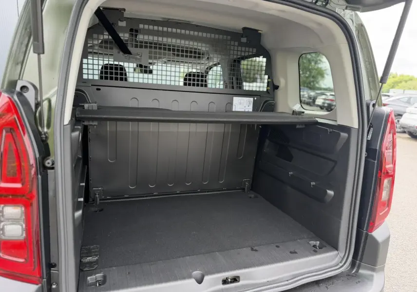 Coffre ouvert vu de l'arrière d'un Citroën Berlingo Multispace M vert Sirkka avec séparation métallique et lunette arrière ouvrante.