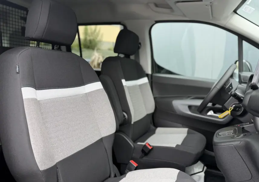 Vue intérieure côté droit du Citroën Berlingo Multispace 2026, sièges tissu gris et noir avec volant multifonctions.