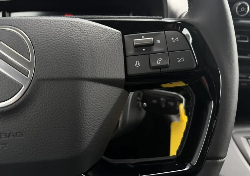 Gros plan sur les commandes multifonctions du volant cuir noir du Citroën Berlingo Multispace 2026.