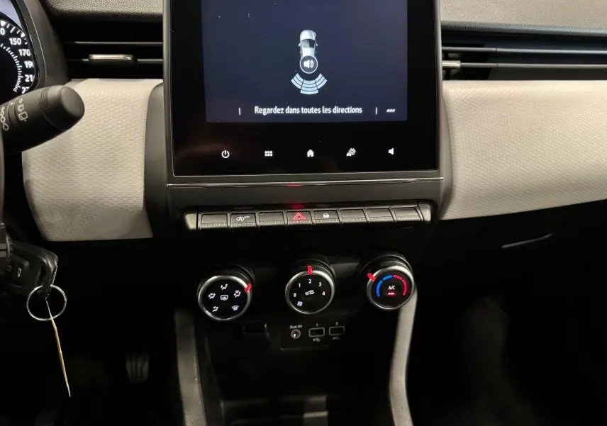 Vue rapprochée du tableau de bord de la Renault Clio V 2022, avec écran tactile et commandes de climatisation.