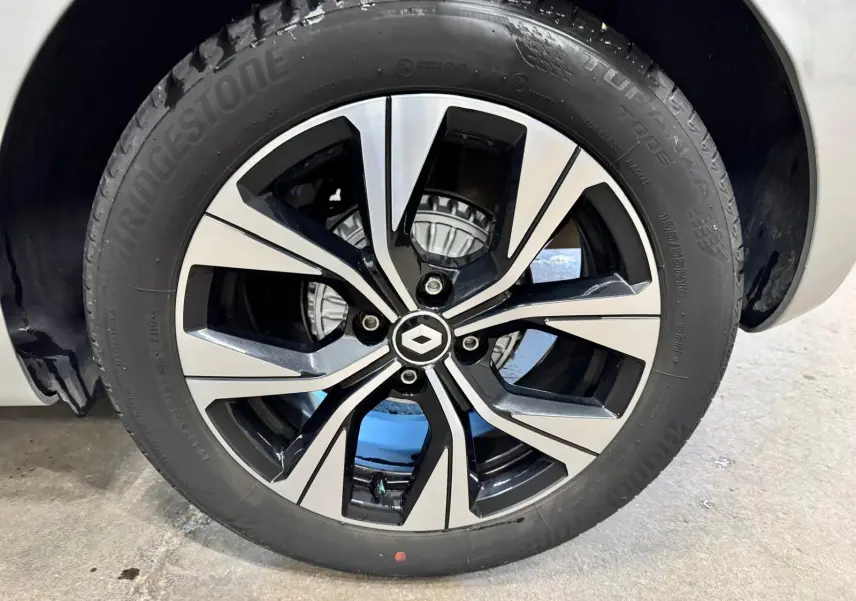Gros plan sur la jante alliage biton 16 pouces de la Renault Clio V gris aluminium, avec logo Renault au centre.