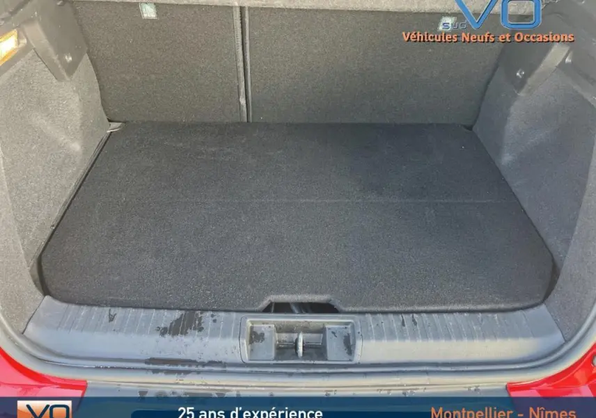 Coffre ouvert du Renault Captur E-Tech Plug-in rouge, montrant l'espace de chargement propre et bien fini.