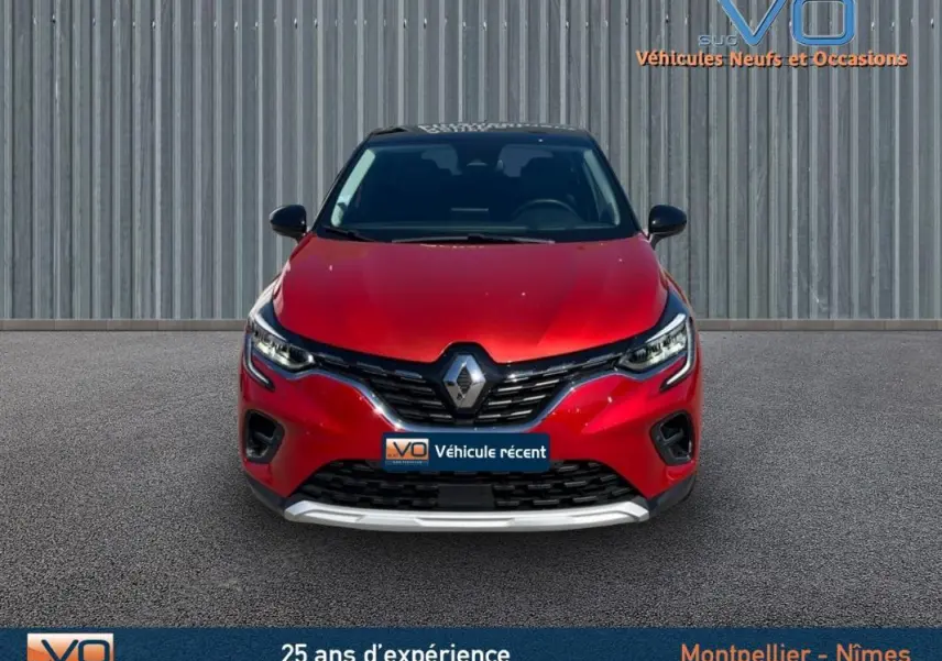 Vue avant d'un Renault Captur E-Tech Plug-in 160 Intens rouge avec calandre noire et logo chromé visible.