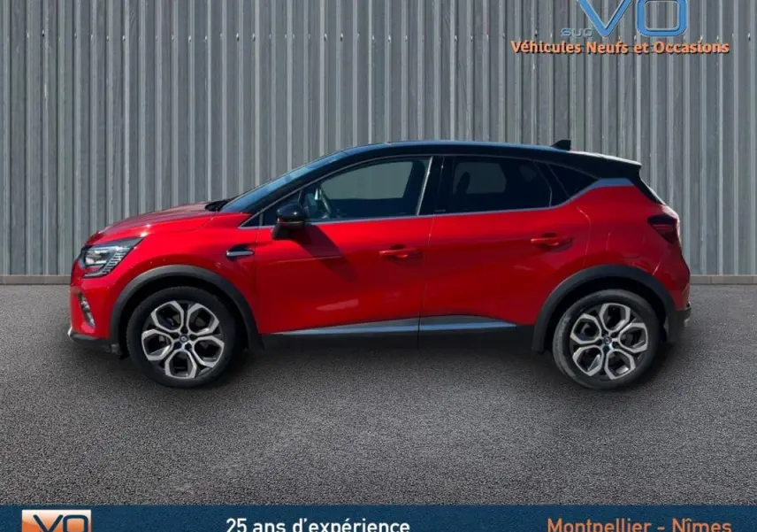 Profil côté gauche d'un Renault Captur rouge E-Tech Plug-in 160 Intens avec jantes alliage 18 pouces sur fond urbain.
