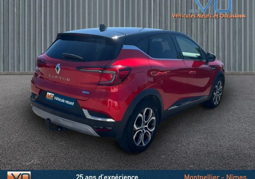 Vue 3/4 arrière droite d'un Renault Captur E-Tech Plug-in rouge avec jantes alliage 18 pouces et vitres surteintées.