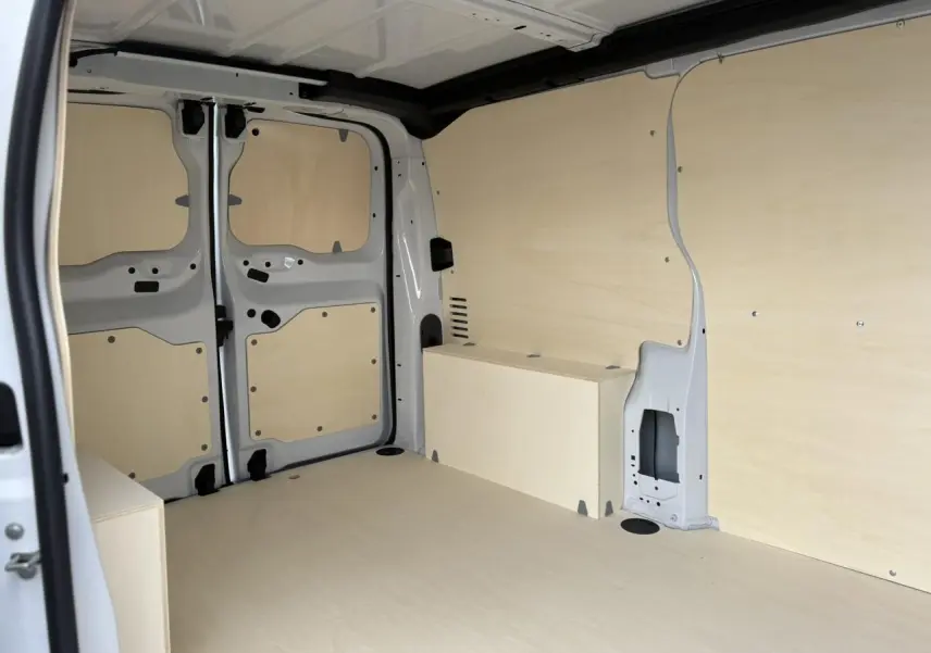 Vue intérieure arrière du Peugeot Expert Fourgon blanc Icy montrant l'espace de chargement avec habillage bois clair.