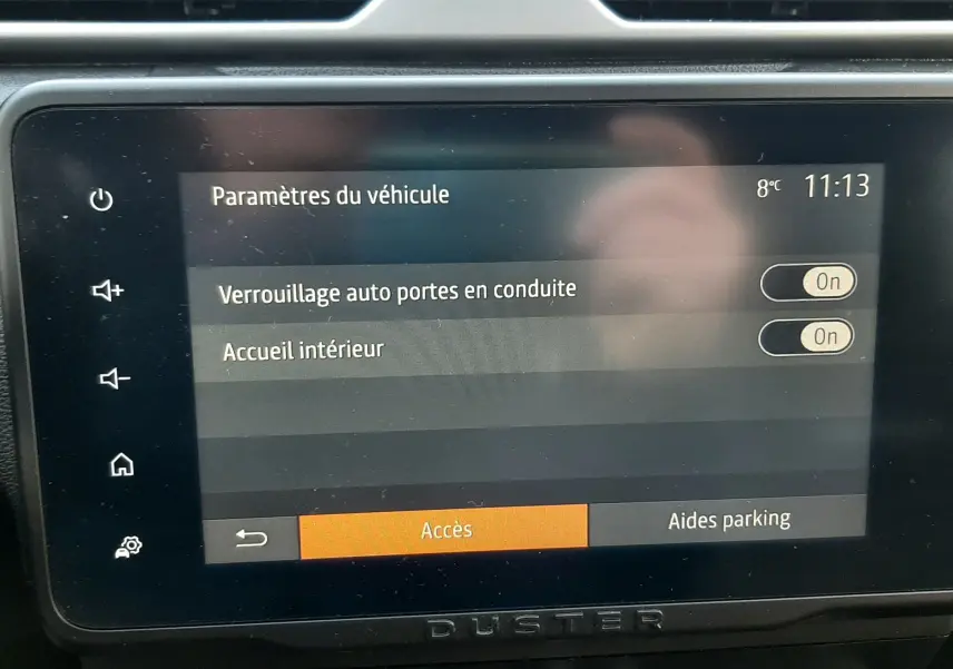 Écran tactile central du Dacia Duster 2023 affichant les paramètres du véhicule, avec commandes et aérateurs visibles.