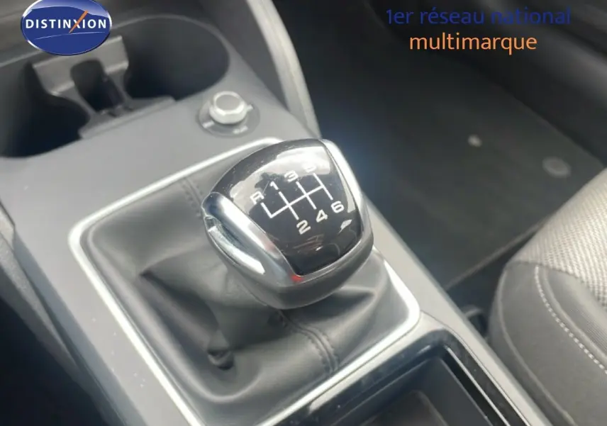 Gros plan sur le levier de vitesses manuel noir de l'Audi Q2 30 TDI S-Line, avec console grise et siège tissu visible.