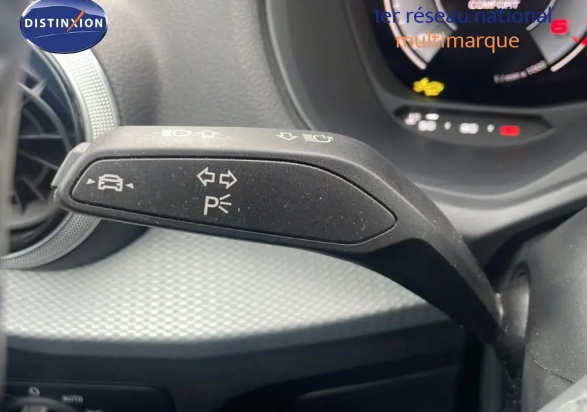 Gros plan sur la commande de clignotant à gauche dans l’habitacle noir du Audi Q2 30 TDI S-Line 2025.