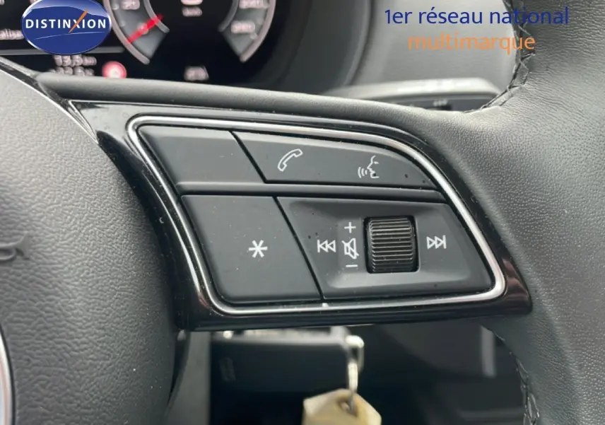 Gros plan sur les commandes multimédia au volant cuir noir de l'Audi Q2 30 TDI S-Line 2025.