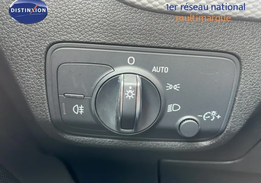 Détail du bouton de commande des phares sur le tableau de bord d’un Audi Q2 noir mito metal 2025.