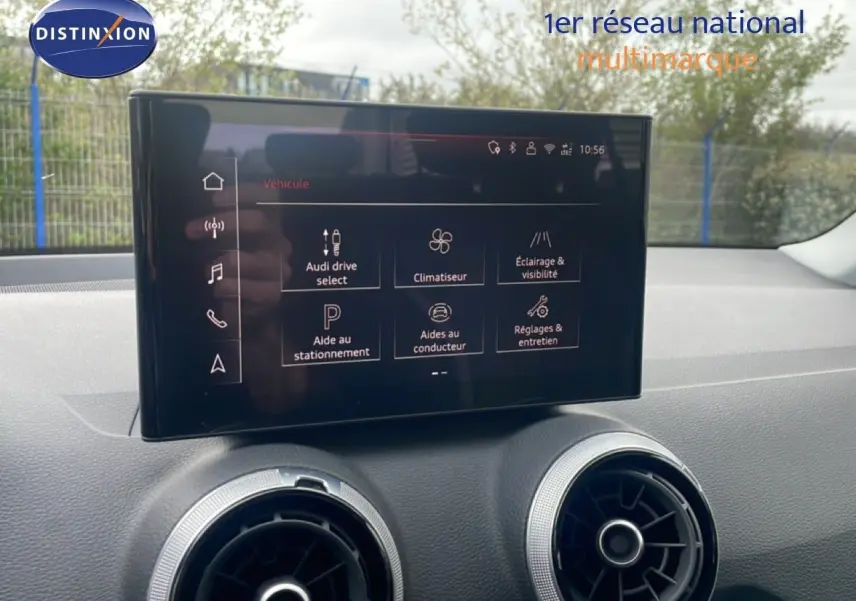 Écran tactile central affichant les options de conduite et assistance dans l’Audi Q2 noir mito metal, vue intérieure frontale.