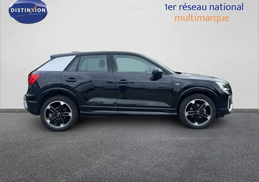 Vue de profil côté gauche d'un Audi Q2 30 TDI S-Line noir mito metal avec jantes alliage noires.