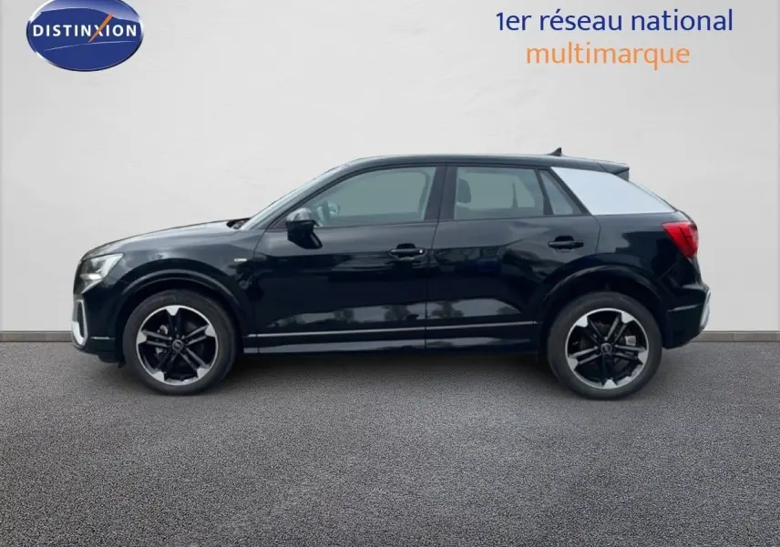 Profil latéral droit d'un Audi Q2 30 TDI S-Line noir mito metal avec jantes noires et toit contrasté gris clair.