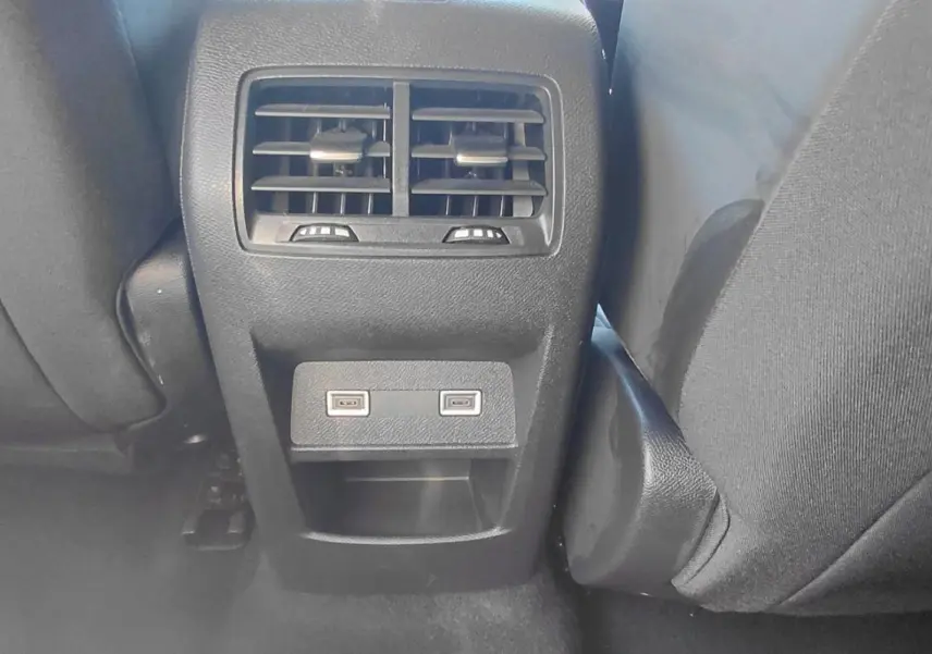 Vue rapprochée des aérateurs arrière et des deux ports USB situés entre les sièges arrière d'une Peugeot 308 gris 2025.