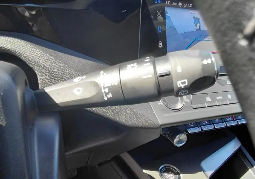 Gros plan sur la commande d’essuie-glace à gauche du volant dans l’habitacle gris du Peugeot 308 2025.