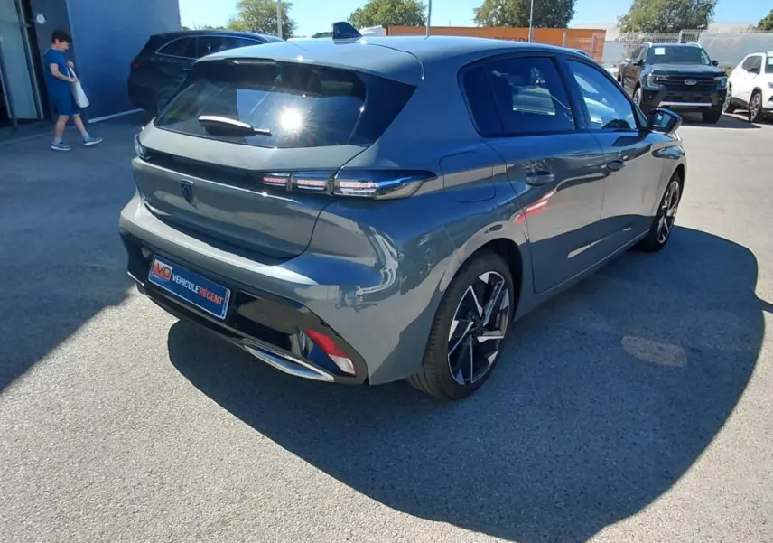 PEUGEOT 308 BlueHDi gris vue 3/4 arrière droit, avec feux arrière LED et jantes alliage distinctives.