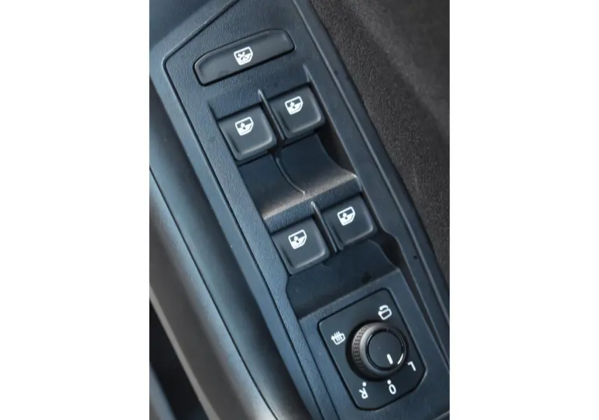 Gros plan sur les commandes des vitres et rétroviseurs du Volkswagen T-Roc 2025, intérieur noir.