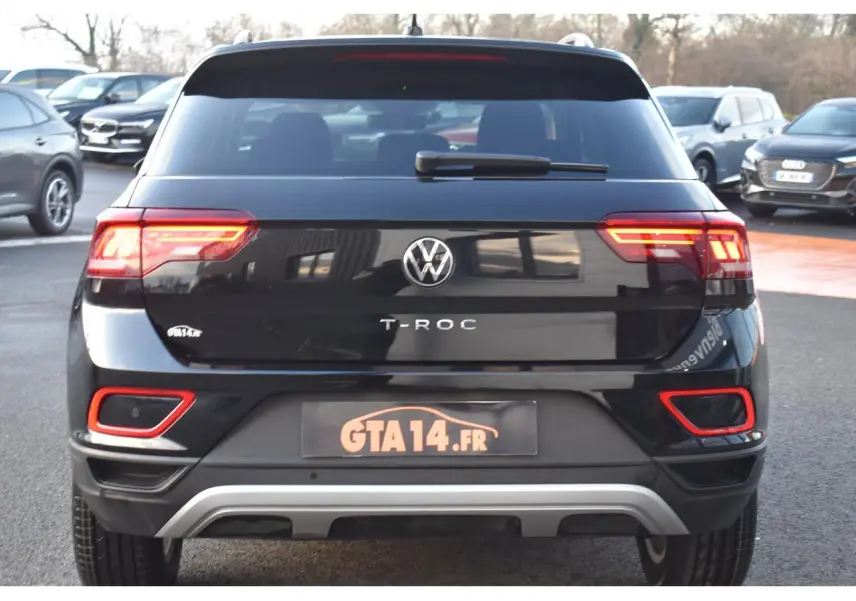 Vue arrière d'un Volkswagen T-Roc 2025 noir Grenadilla avec feux LED et détails rouges sur le pare-chocs.