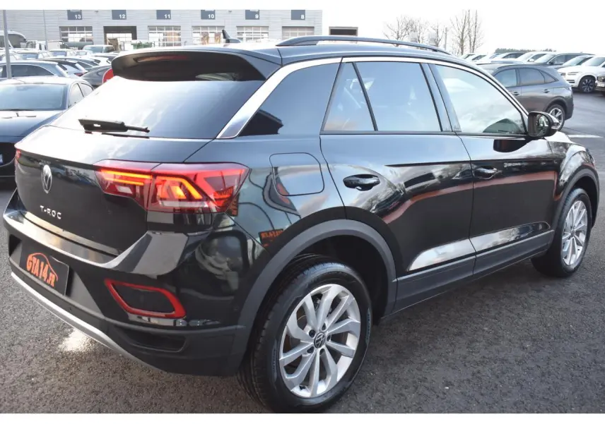 Volkswagen T-Roc 2025 noir Grenadilla, vue 3/4 arrière droit avec jantes alliage 17 pouces et feux LED allumés.