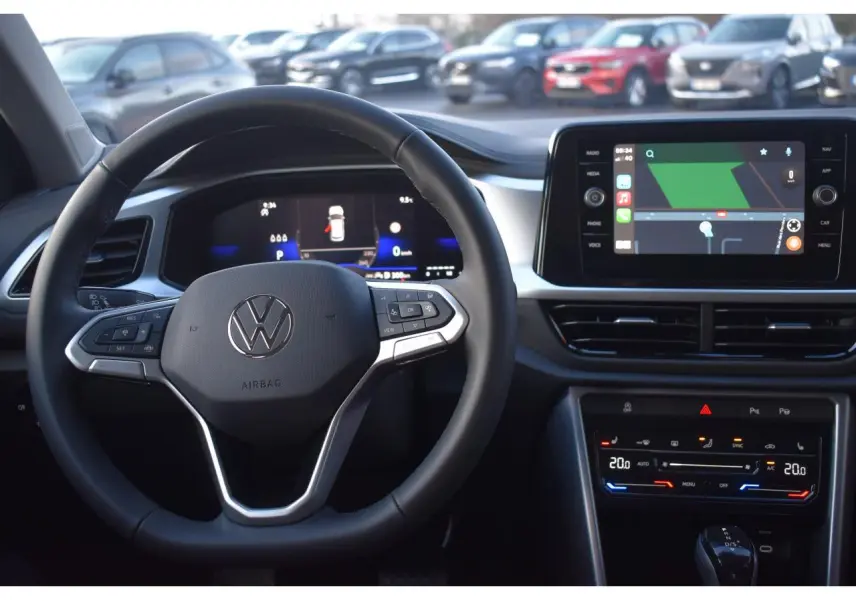 Vue intérieure centrée sur le volant multifonction et l'écran tactile du Volkswagen T-Roc 2025, tableau de bord moderne.