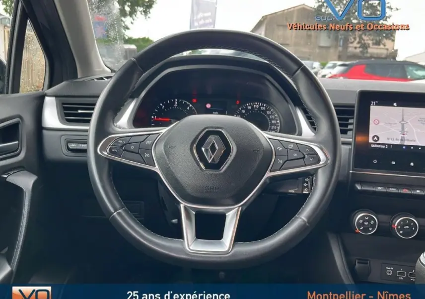 Vue centrée sur le volant du Renault Captur gris 2021, avec tableau de bord et écran tactile visibles.