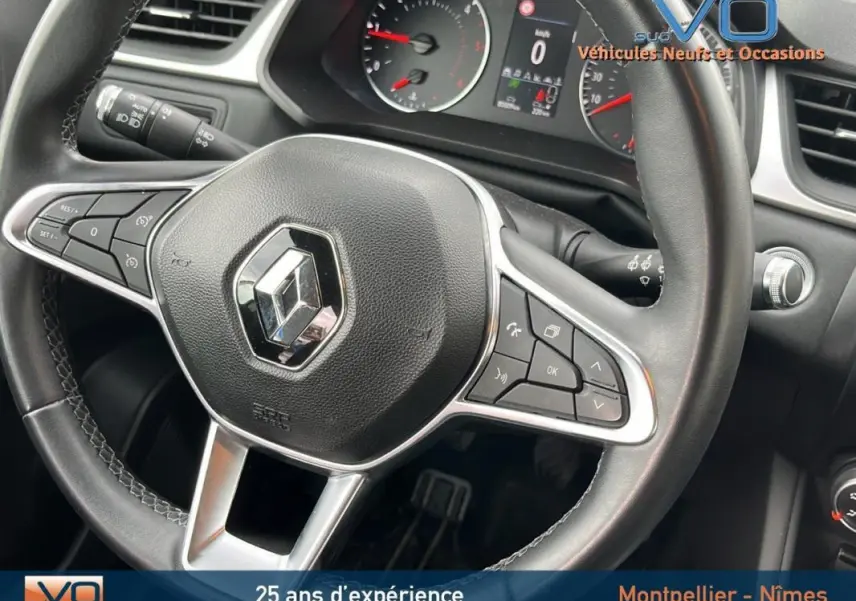 Vue rapprochée du volant multifonction noir avec logo Renault du tableau de bord du Captur gris 2021.