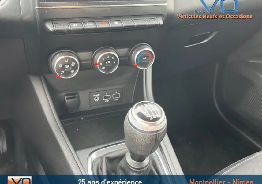 Gros plan sur la commande de boîte manuelle et les réglages de climatisation du Renault Captur gris Blue dCi 115 Business 2021.