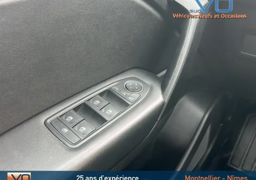 Gros plan sur les commandes des vitres électriques côté conducteur du Renault Captur gris Blue dCi 115 Business 2021.