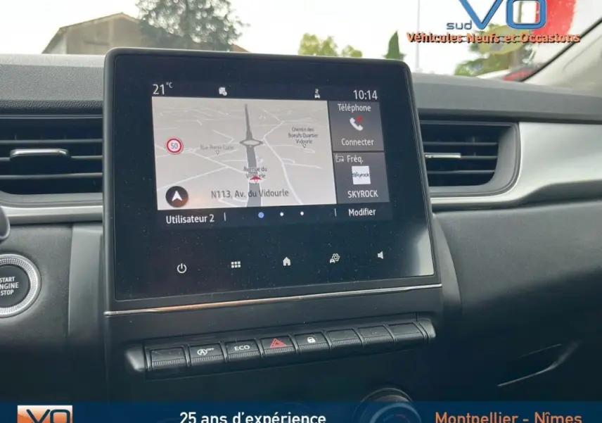 Tableau de bord du Renault Captur gris 2021 avec écran tactile affichant la navigation et commandes intégrées.