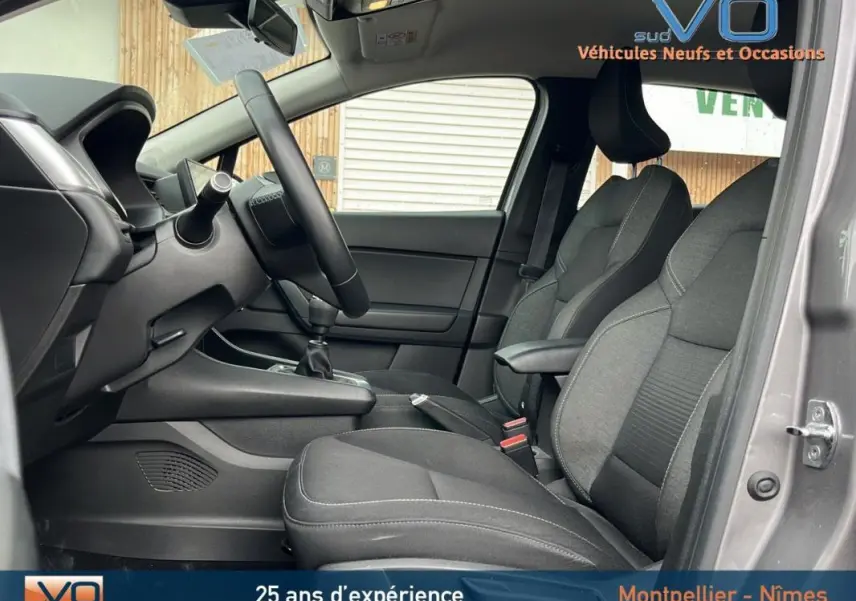Intérieur avant du Renault Captur gris 2021, montrant les sièges tissu et la boîte manuelle côté conducteur.