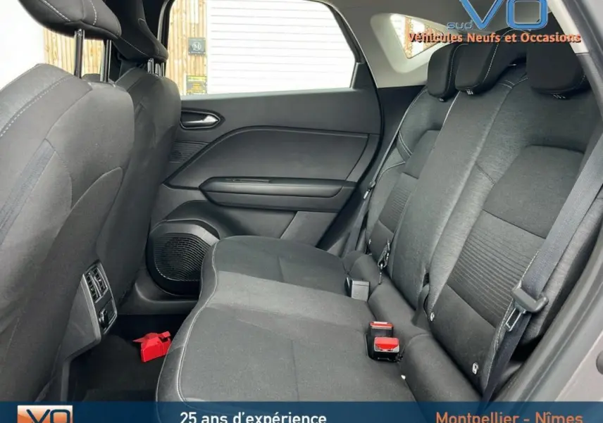 Vue latérale droite de l'intérieur arrière du Renault Captur gris 2021, montrant les sièges en tissu et les ceintures de sécurité.