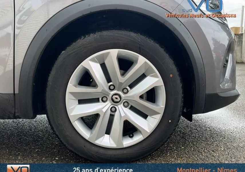 Gros plan sur la roue avant droite d’un Renault Captur gris 2021 avec jante alliage distinctive.