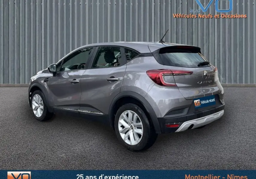 Vue 3/4 arrière droite d'un Renault Captur gris 2021, avec jantes argentées et feux arrière LED distinctifs.
