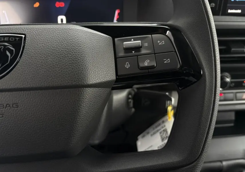 Gros plan sur le volant noir du Peugeot Expert Fourgon 2025 avec commandes vocales et téléphoniques intégrées.