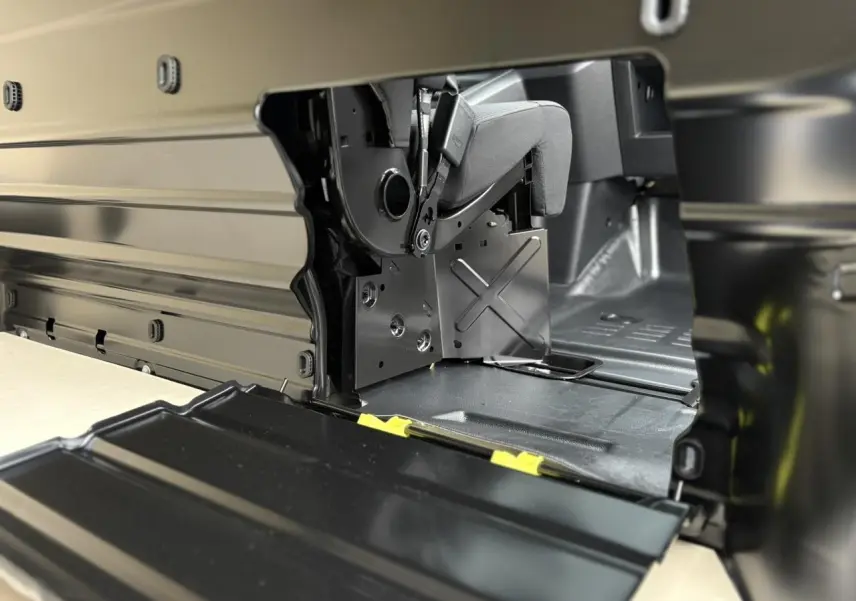 Détail intérieur du compartiment de chargement du Peugeot Expert Fourgon blanc, montrant la banquette passager relevée.