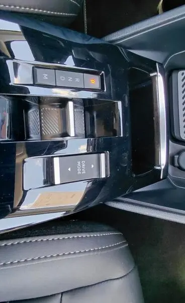 Vue rapprochée de la console centrale noire du Citroën C4 X hybride 2025 avec commandes de boîte auto et mode de conduite.