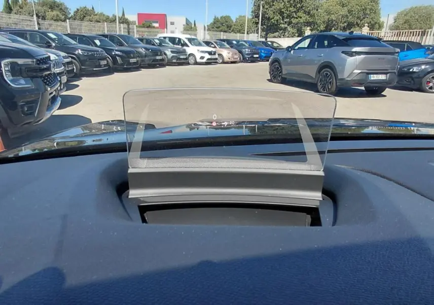 Affichage tête haute transparent sur le tableau de bord d’une Citroën C4 X noire, vue depuis l’intérieur vers l’avant.